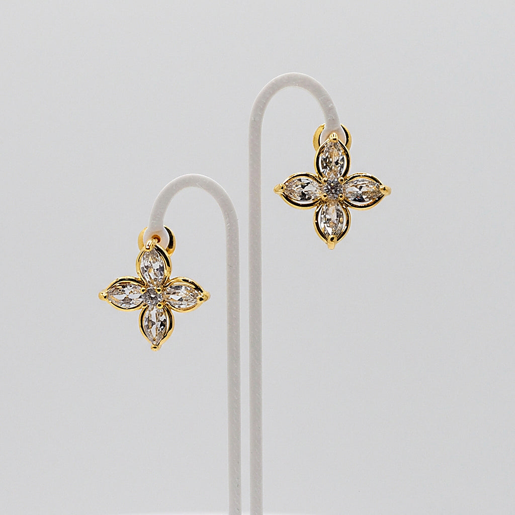 Pair of gold stud earrings on white background