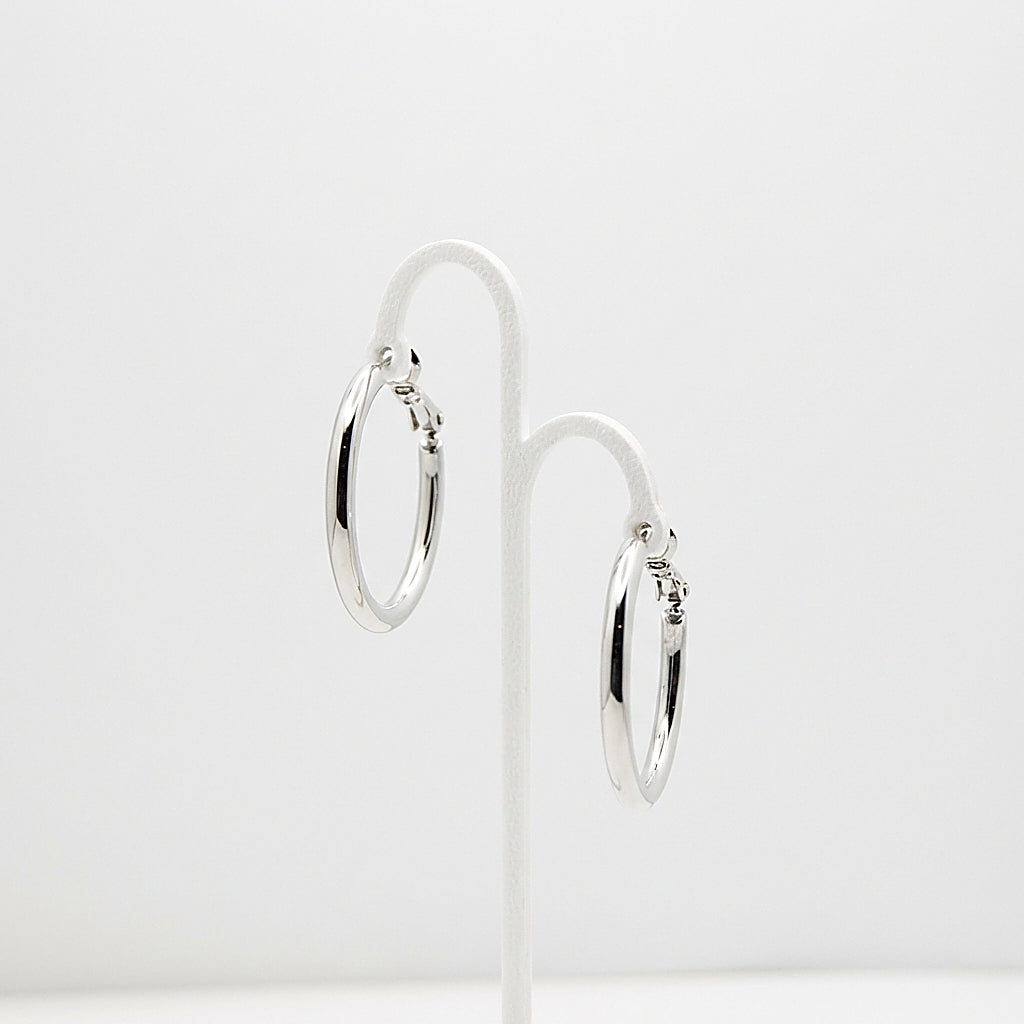 Pair of silver hoop earrings on white background