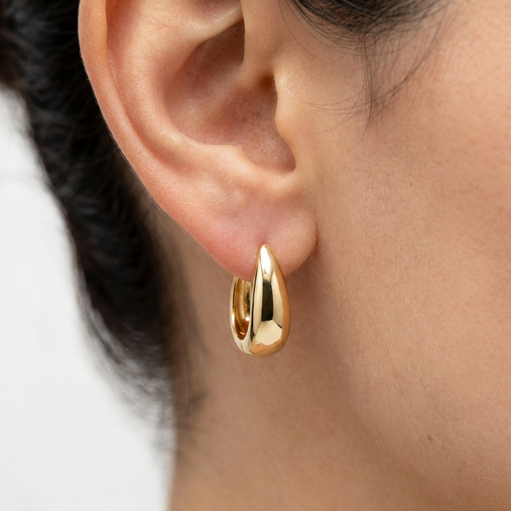 Model wearing gold hoop earrings showing scale