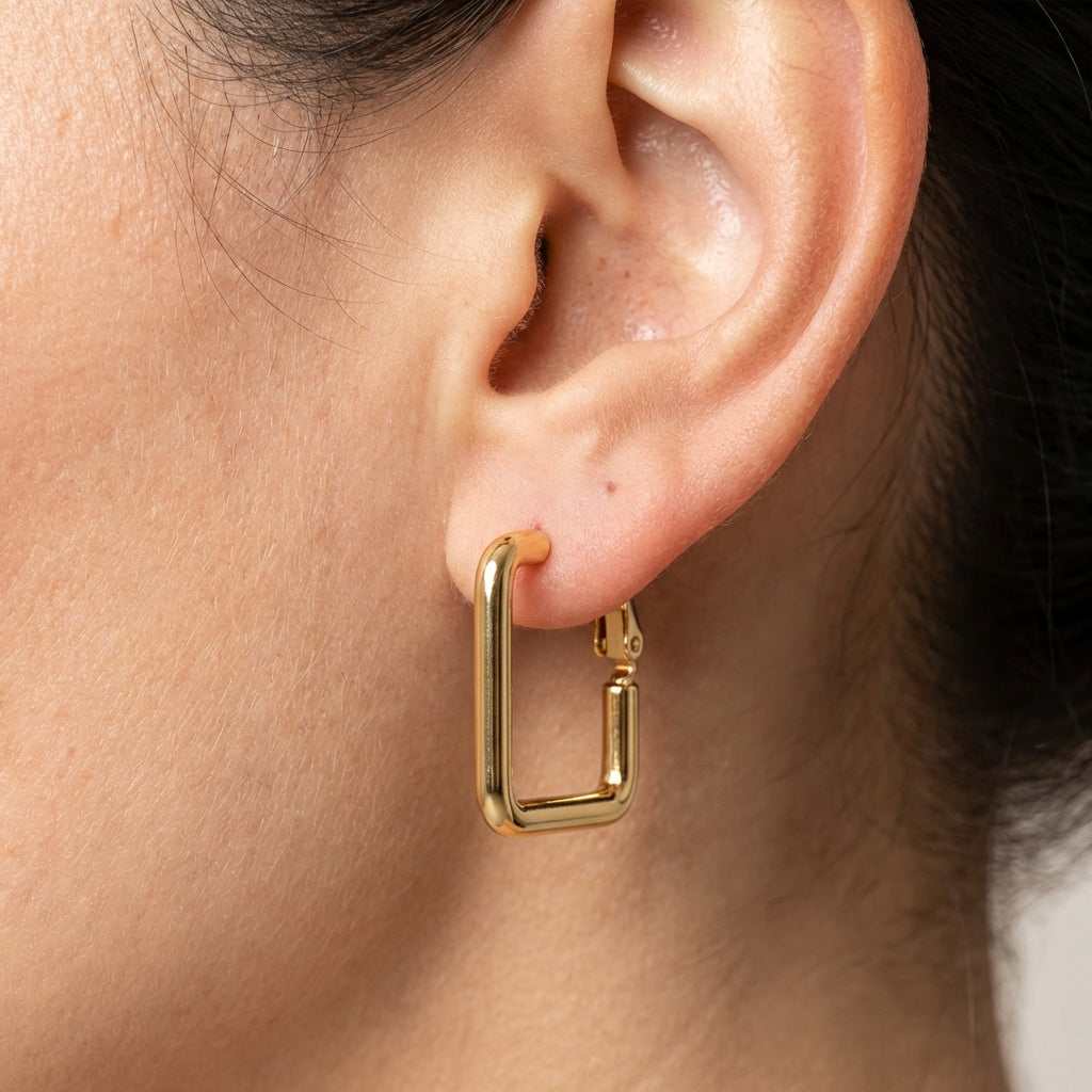 Model wearing gold hoop earrings showing scale