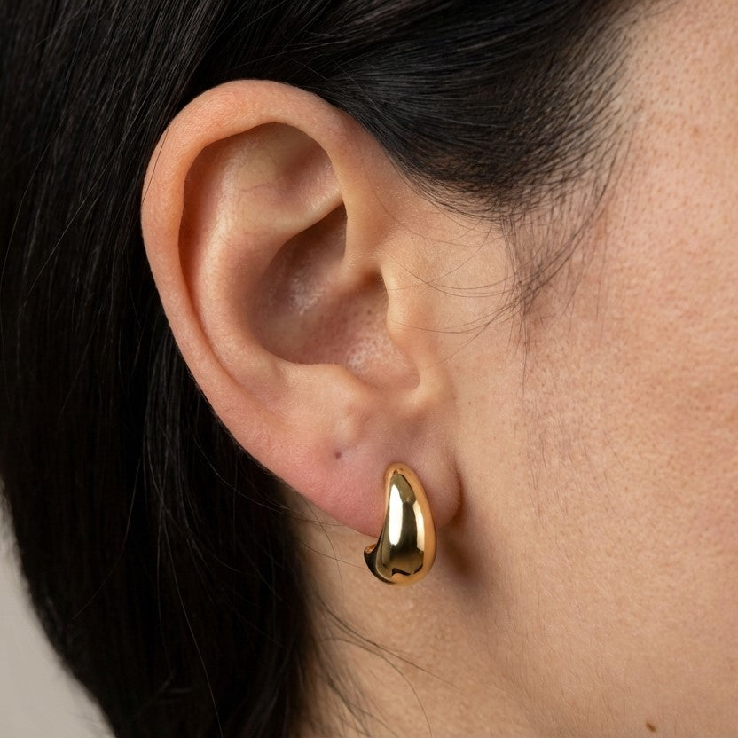 Model wearing gold hoop earrings showing scale