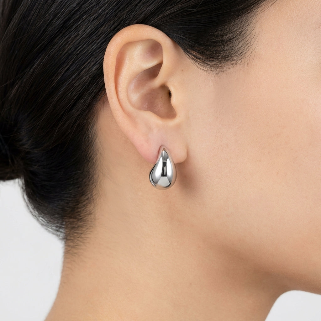 Model wearing silver drop earrings showing scale