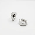 Pair of silver huggie earrings on white background