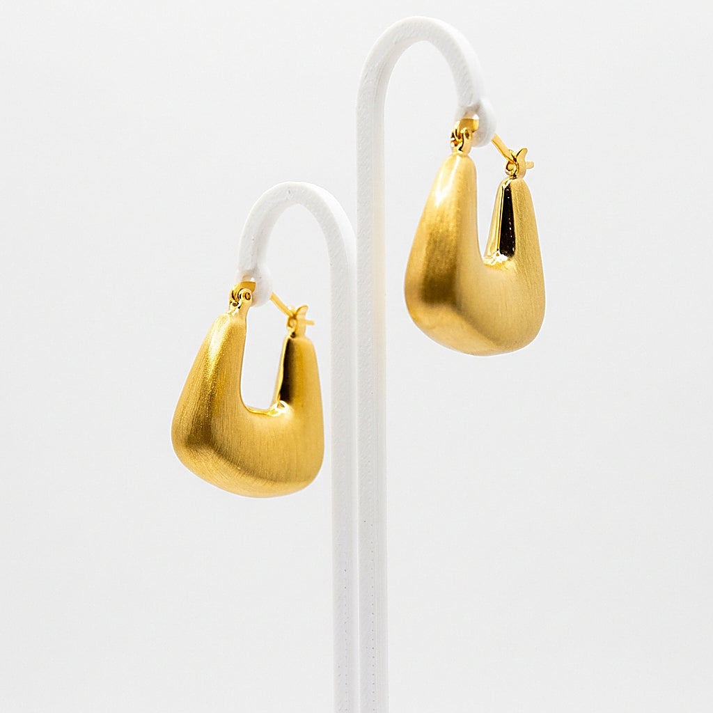 Pair of gold hoop earrings on white background