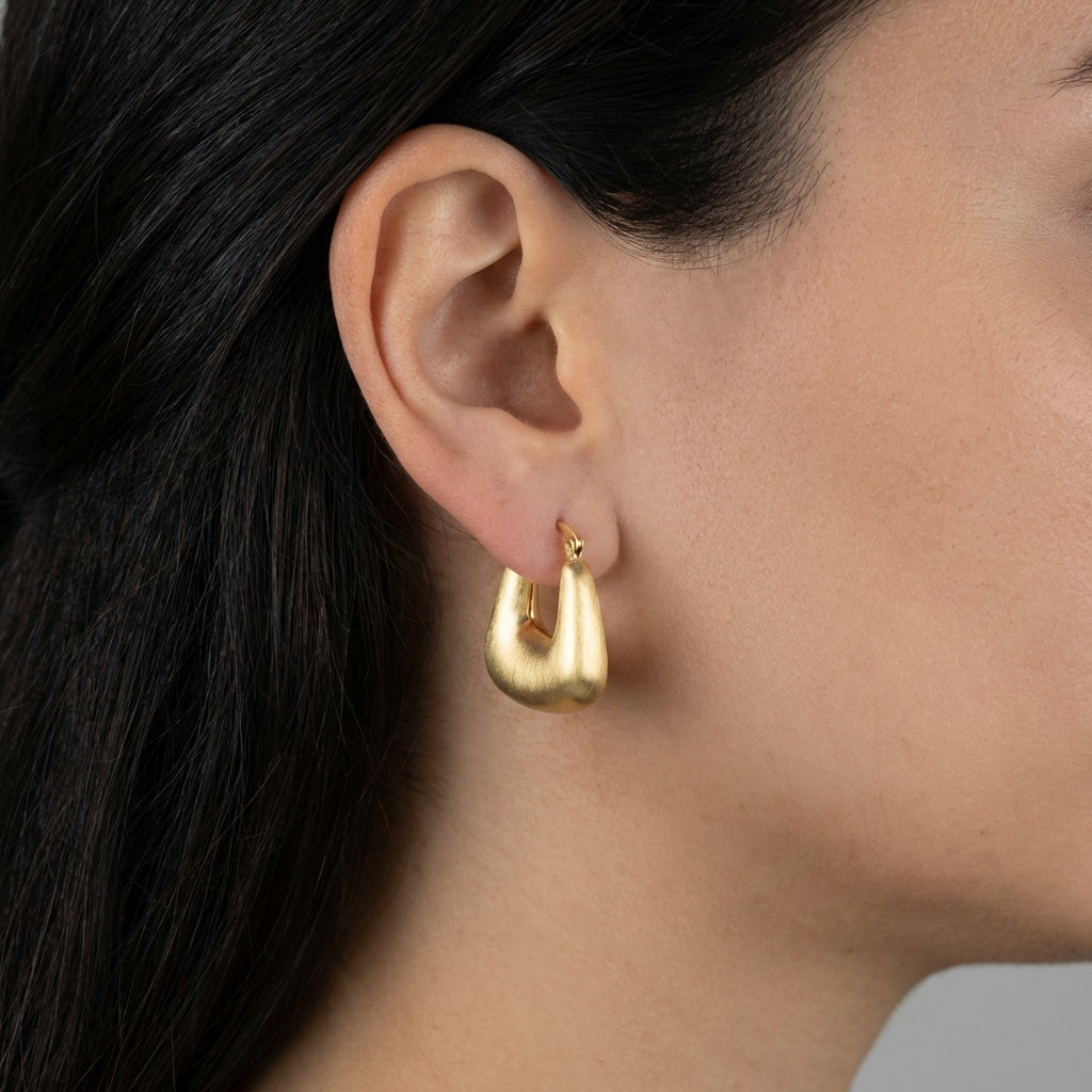 Model wearing gold hoop earrings showing scale