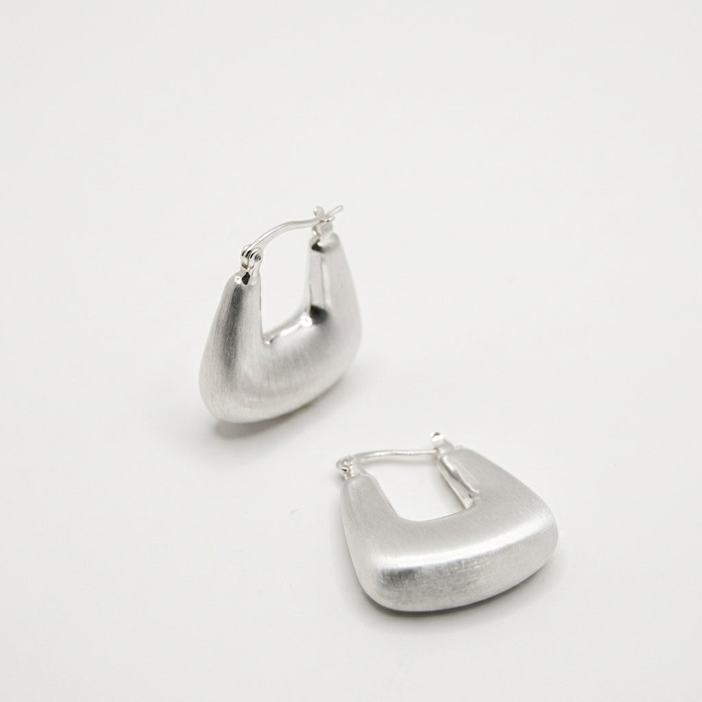 Pair of silver hoop earrings on white background