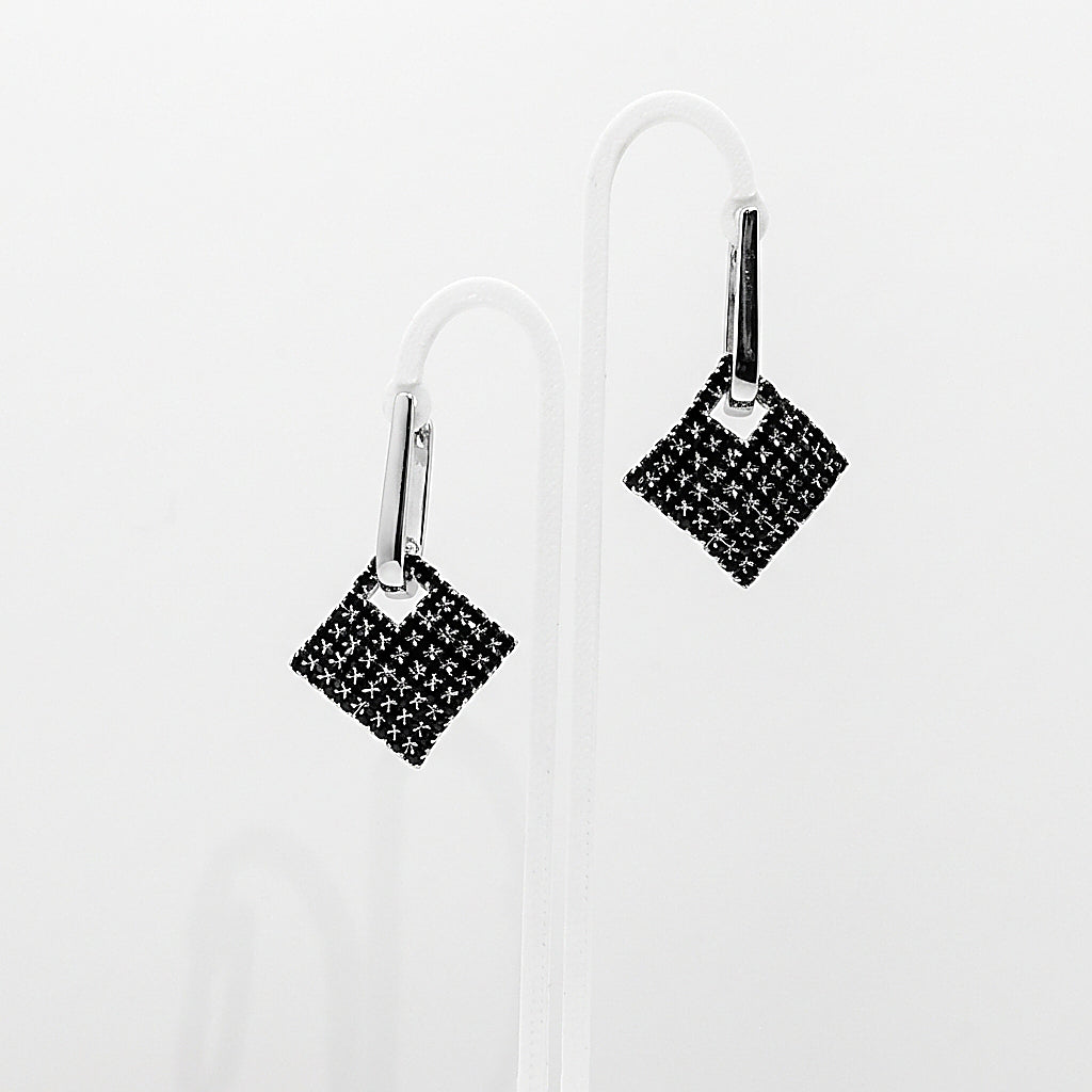 Pair of silver drop earrings on white background