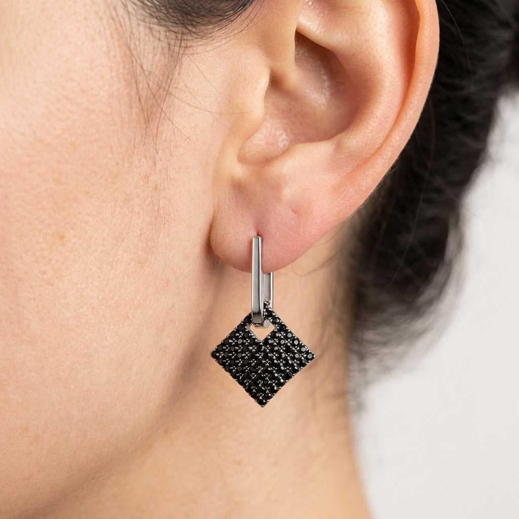 Model wearing silver drop earrings showing scale