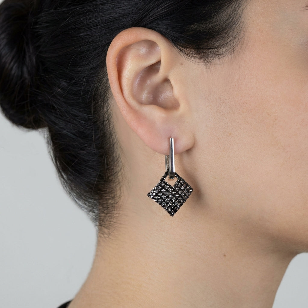 Model wearing silver drop earrings showing scale