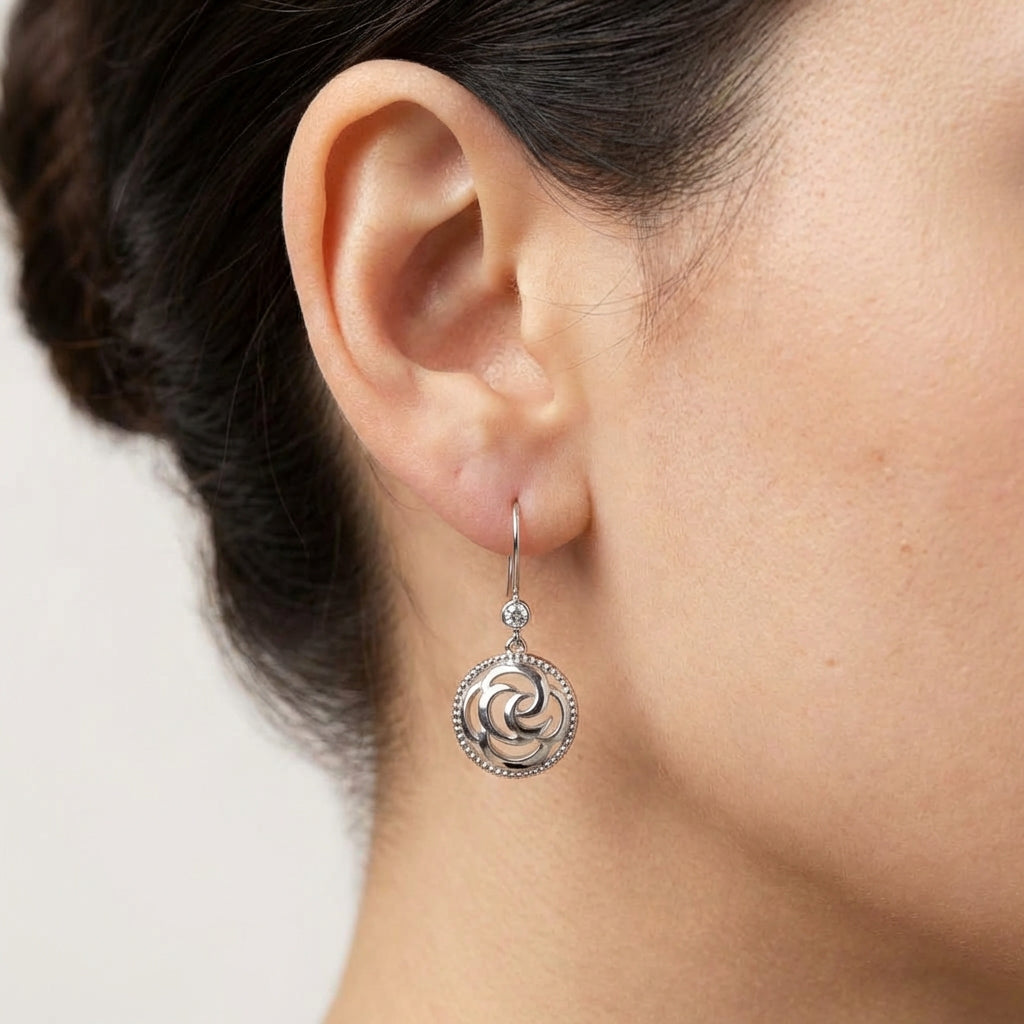 Model wearing silver drop earrings showing scale