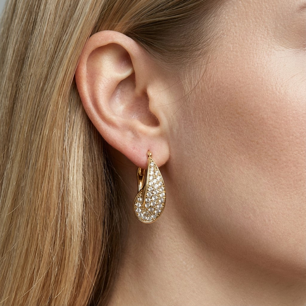 Model wearing gold drop earrings showing scale